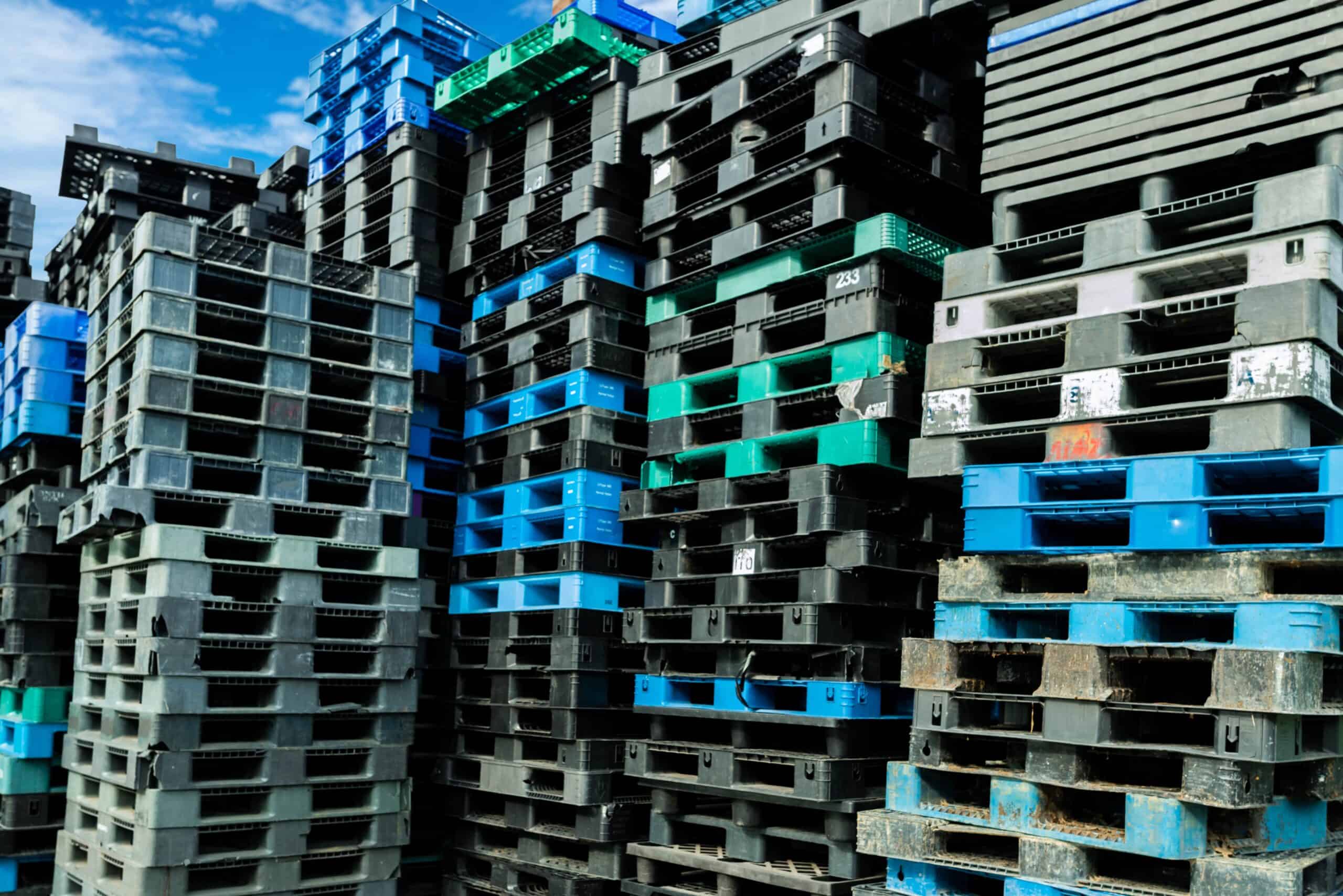Pile of plastic shipping pallet. Industrial plastic pallet stacked at factory warehouse.