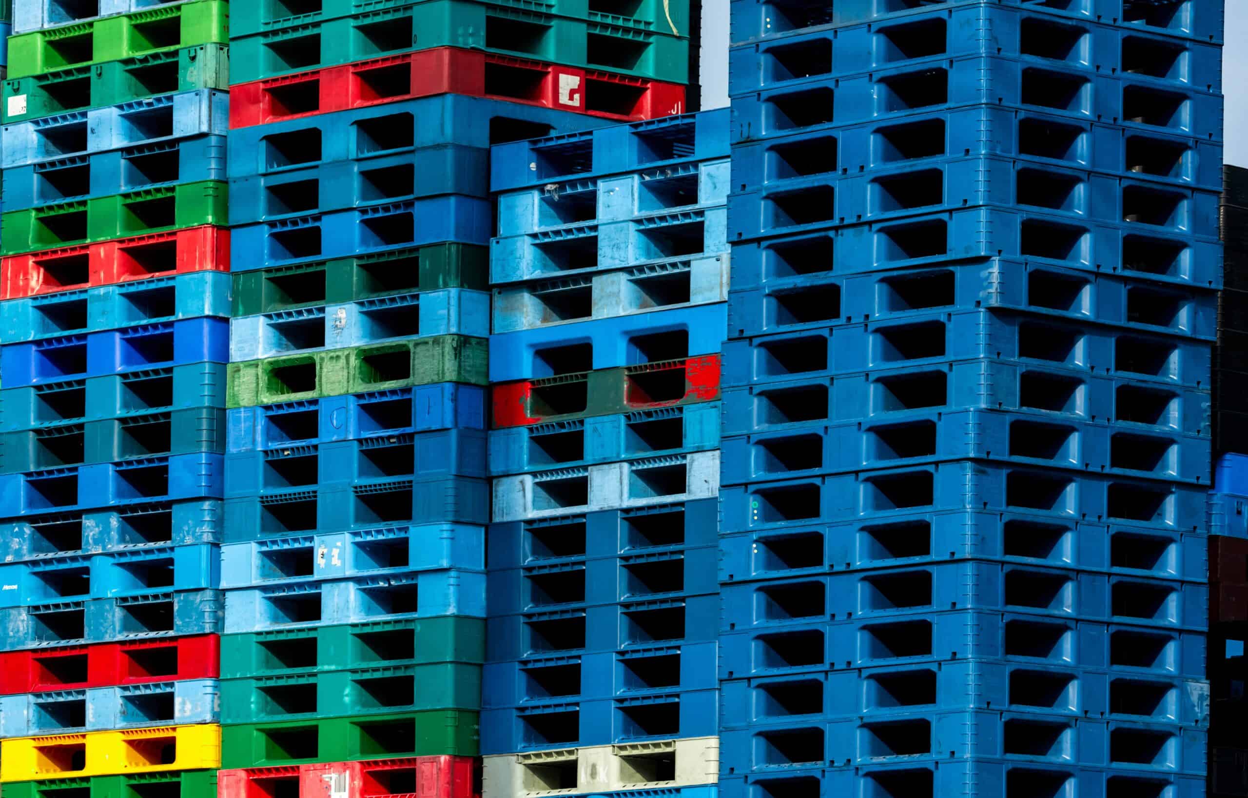 Pile of plastic shipping pallet. Industrial plastic pallet stacked at factory warehouse. Cargo